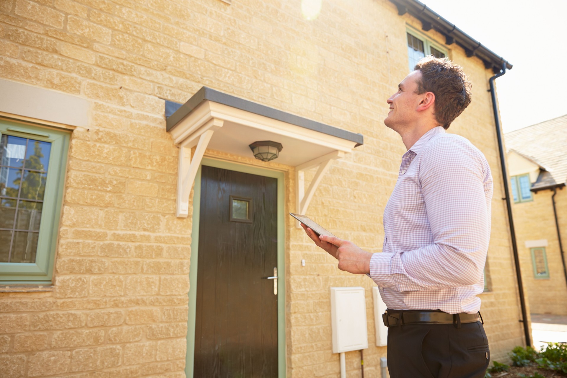 Uomo agente immobiliare guardare un house Esterno